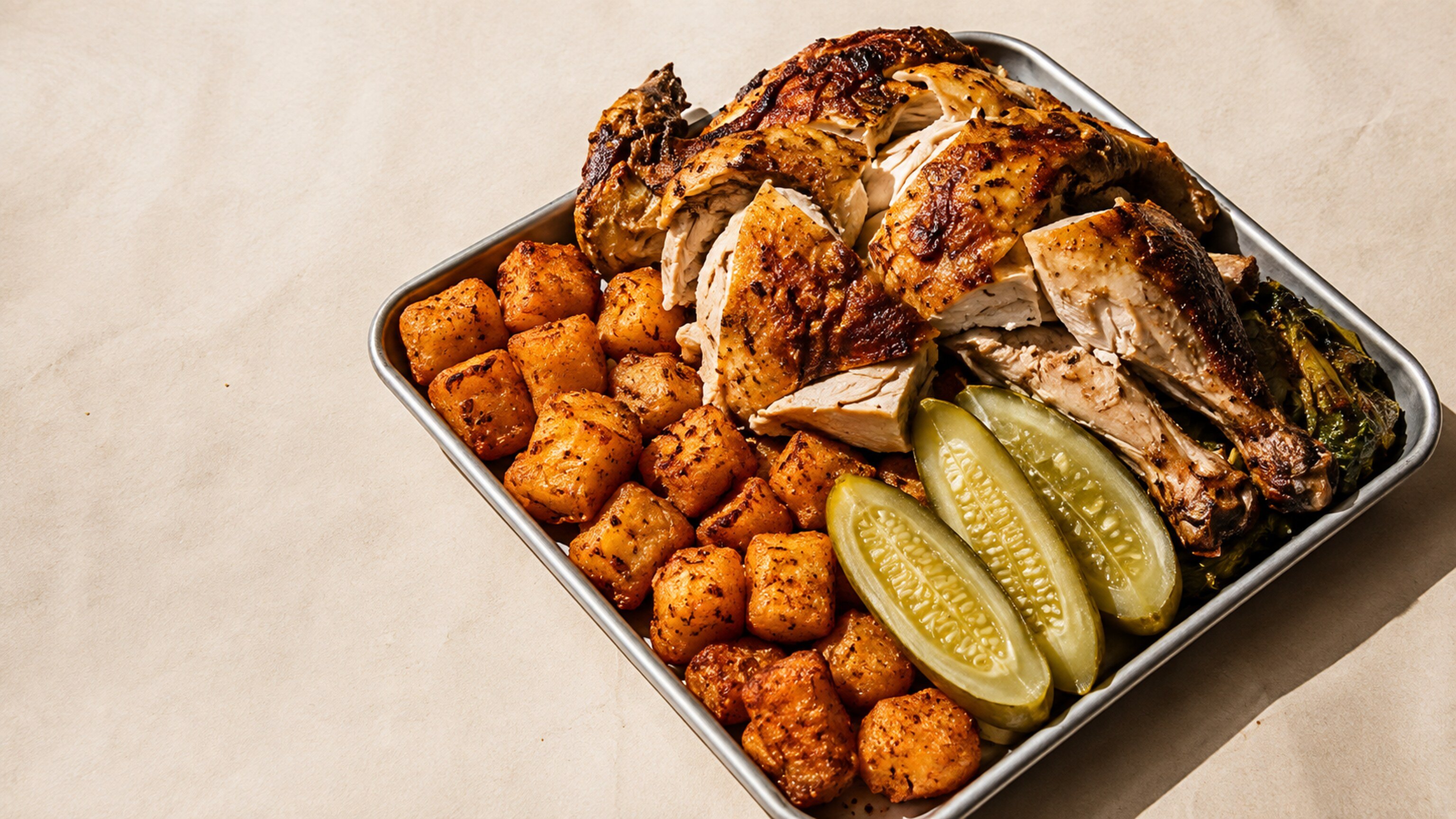 HOUSE ISSUE: a rotisserie chicken and crispy potatoes on a metal tray