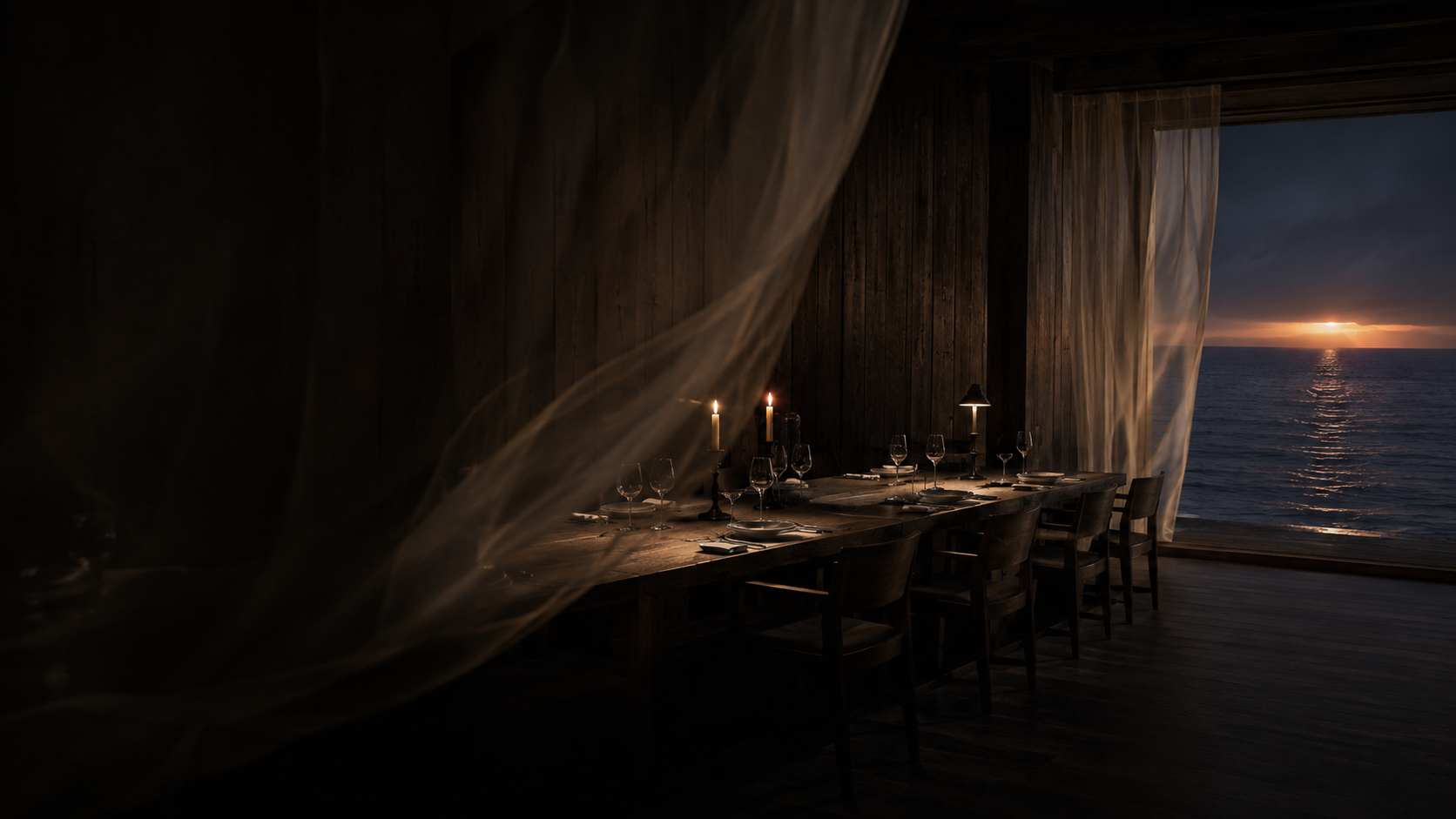 The dining room at dusk: one long candlelit table facing the Pacific